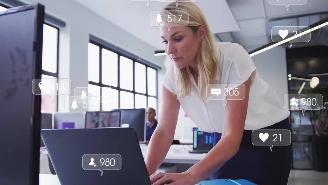 Animation of social media icons and numbers over caucasian businesswoman using laptop