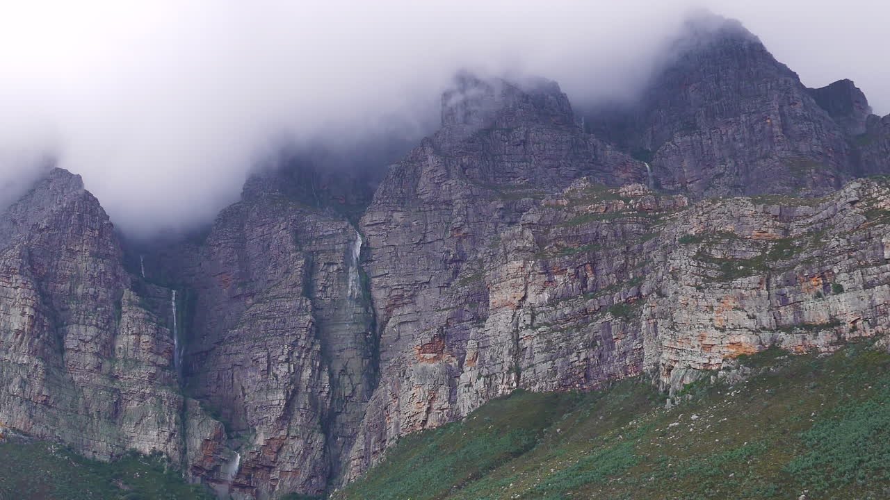 Diverse piccole cascate che scendono lungo il fianco della montagna dopo forti piogge, Du Toit's Kloof, Sudafrica, ripresa ravvicinata.