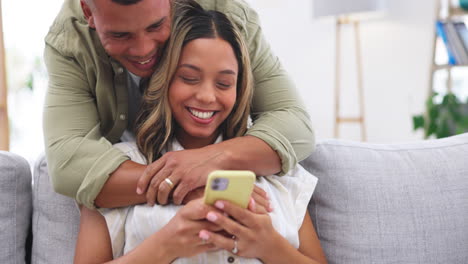 Couple,-couch-and-hug-from-behind-in-home