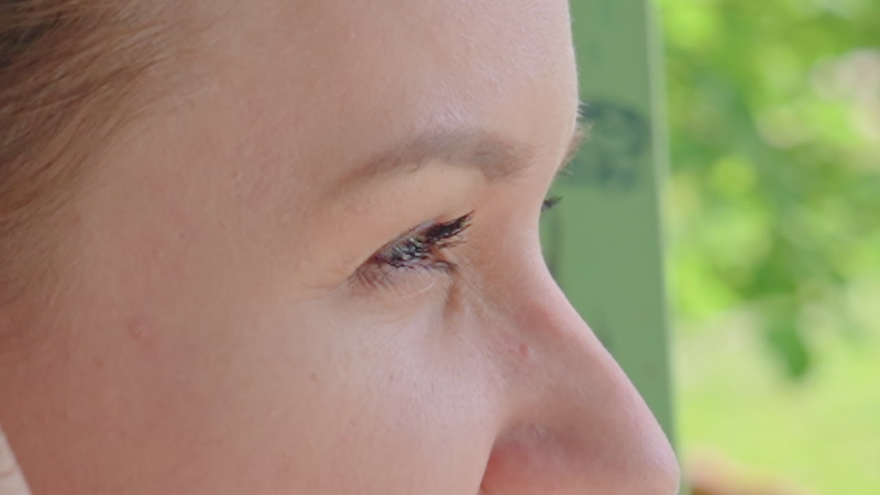 우아한 여성이 미소 짓고 있는 모습이에요. 빛나는 녹색 눈과 부드러운 이목구비를 가진 백인 여성의 클로즈업 샷으로, 따뜻한 햇빛 아래 몽환적인 표정과 은은한 미소를 짓고 있는 하얀 피부의 여성을 담아낸 섬세한 이미지예요.