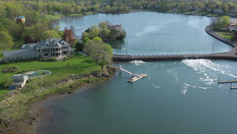 an aerial view over waterfront properties surrounded by green trees on a sunny day