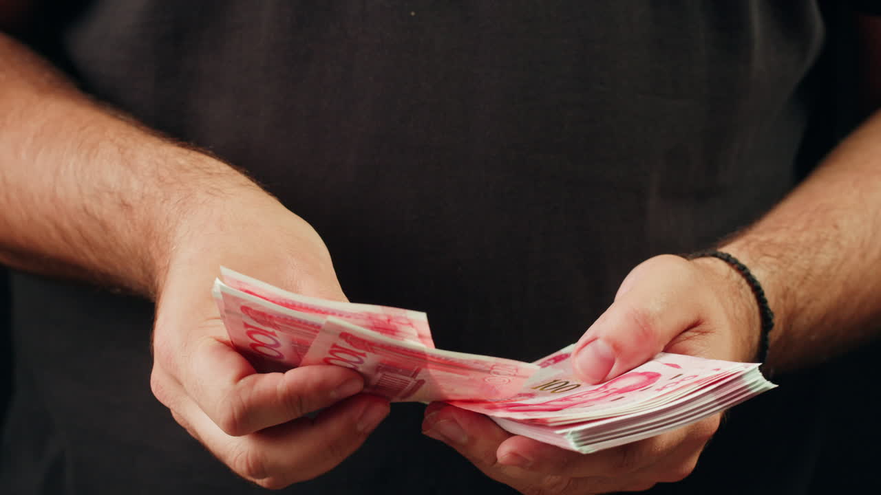 Persoon die Chinese Yuan bankbiljetten vasthoudt