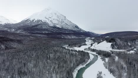 drone se aleja de la cordillera a lo largo del río congelado de alaska