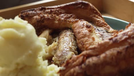 close up of british food toad in the hole with mashed potato