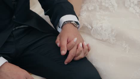 bride and groom holding hands in wedding attire during ceremony moment