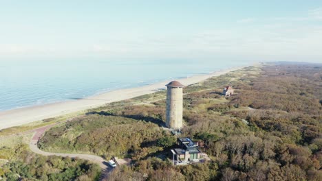 Toma-Aérea-De-La-Torre-En-Domburg,-Zelanda-Con-Vista-Al-Mar.