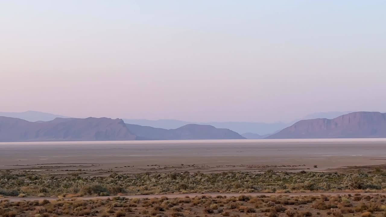 maravilloso color púrpura rosado del crepúsculo después de la puesta de sol en el horizonte antes de la noche en el paisaje desértico fondo de montaña lago de sal en amplia vista de la línea del cielo en irán frío pacífico escénico escena plana mínima