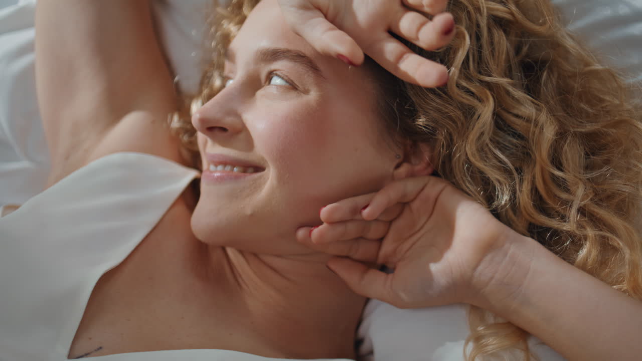Portrait pretty girl waking up in morning sunlight. Smiling woman stretching