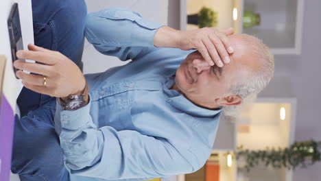 Vertical-video-of-The-old-man-is-breaking-up-with-his-wife-on-the-phone-and-is-upset.