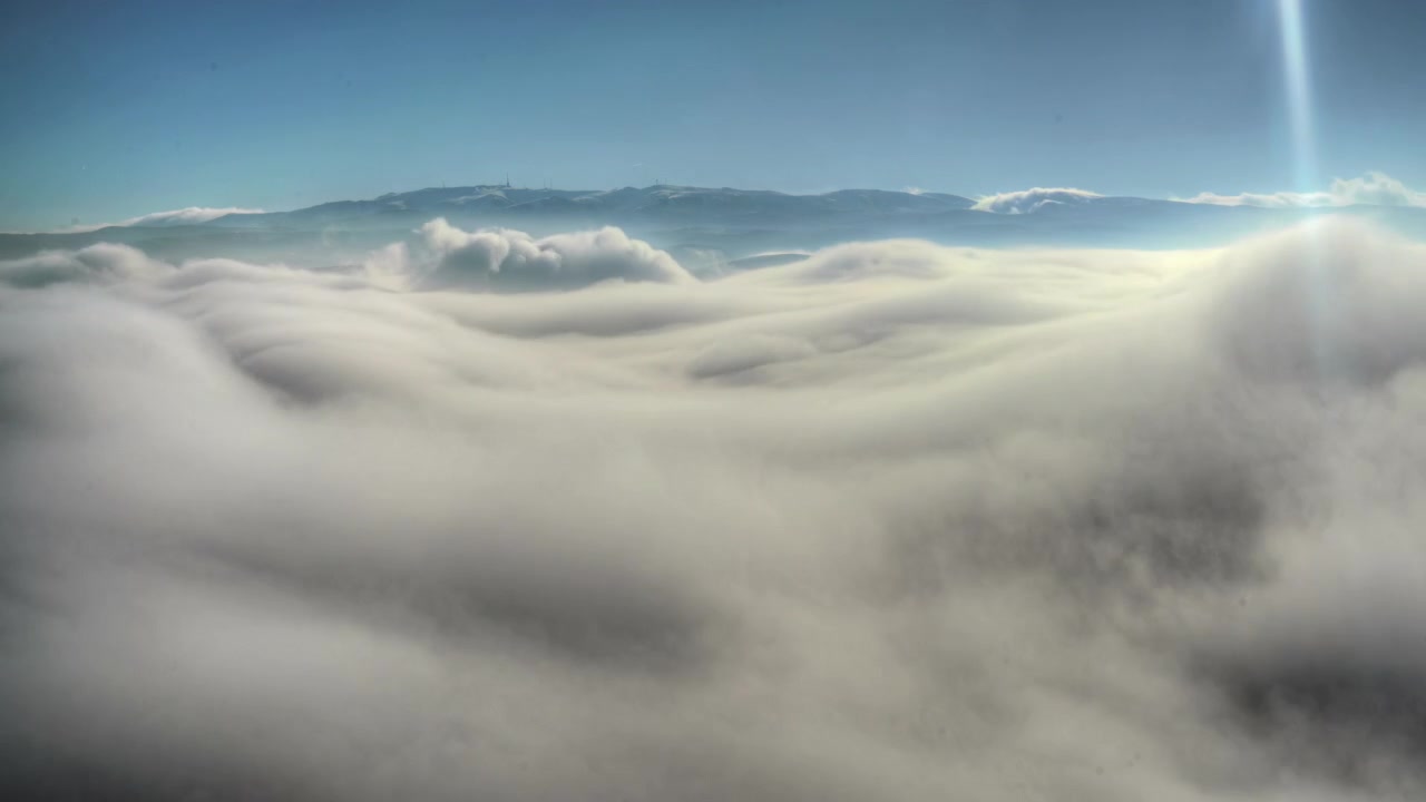 Aerial View of Thick Clouds Over Mountain Range