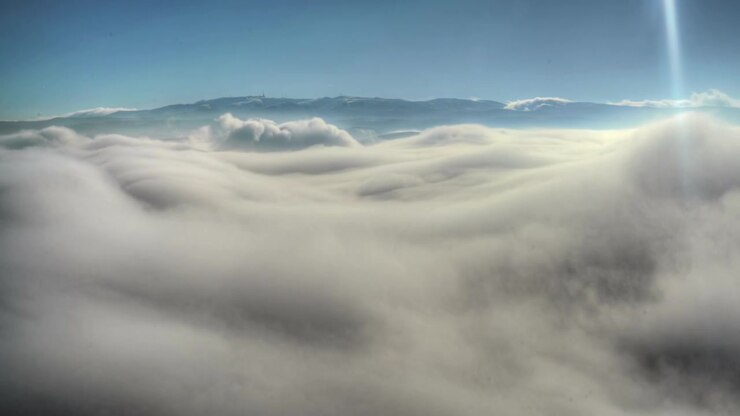 Aerial View of Thick Clouds Over Mountain Range