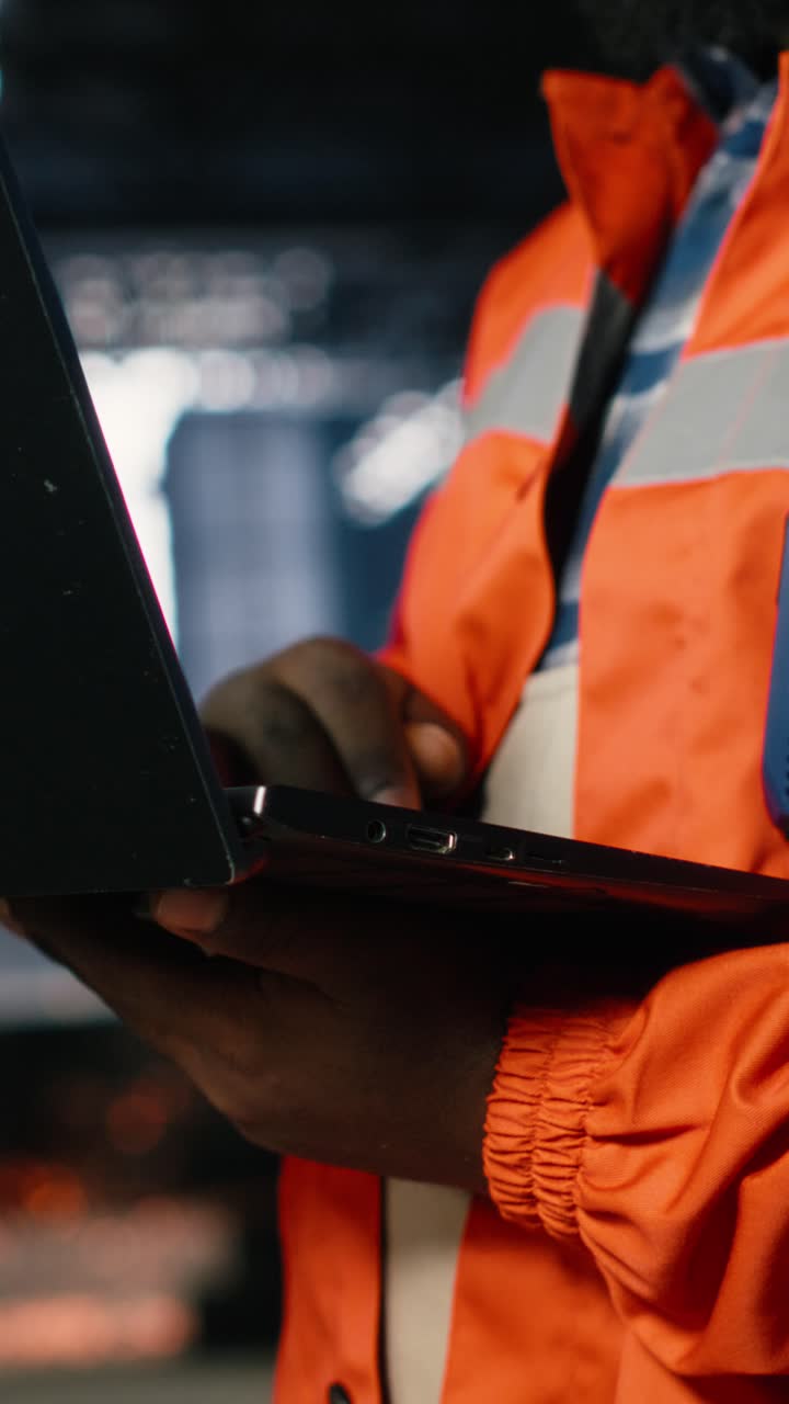 Vertical Video African american supervisor directing production tasks using laptop