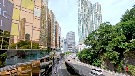 cars drive through urban hong kong landscape