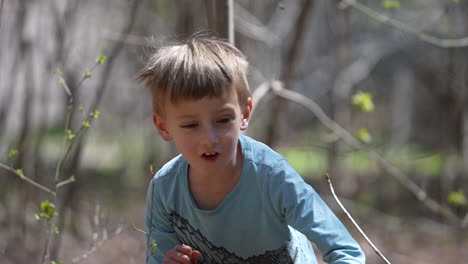 excited little boy running through a forest in slow motion