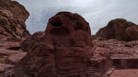 rocks curved by the power of wind. approaching a boulder with a snack crawling by. deserted area in jordan, west asia.