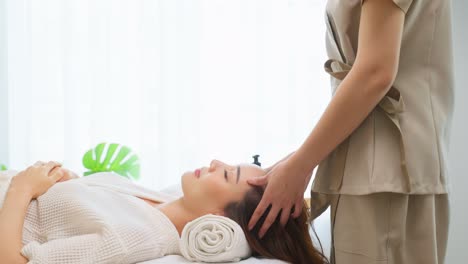 woman receiving a head massage at a spa