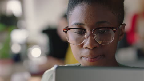 close-up-portrait-beautiful-african-american-woman-using-digital-tablet-computer-in-cafe-drinking-coffee-browsing-online-reading-social-media-messages-watching-entertainment-wearing-glasses