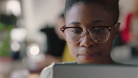 retrato en primer plano de una hermosa mujer afroamericana usando una tableta digital en un café bebiendo café navegando en línea leyendo mensajes de redes sociales viendo entretenimiento usando gafas