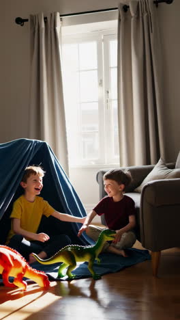 two young boys playing with dinosaurs in a blanket fort