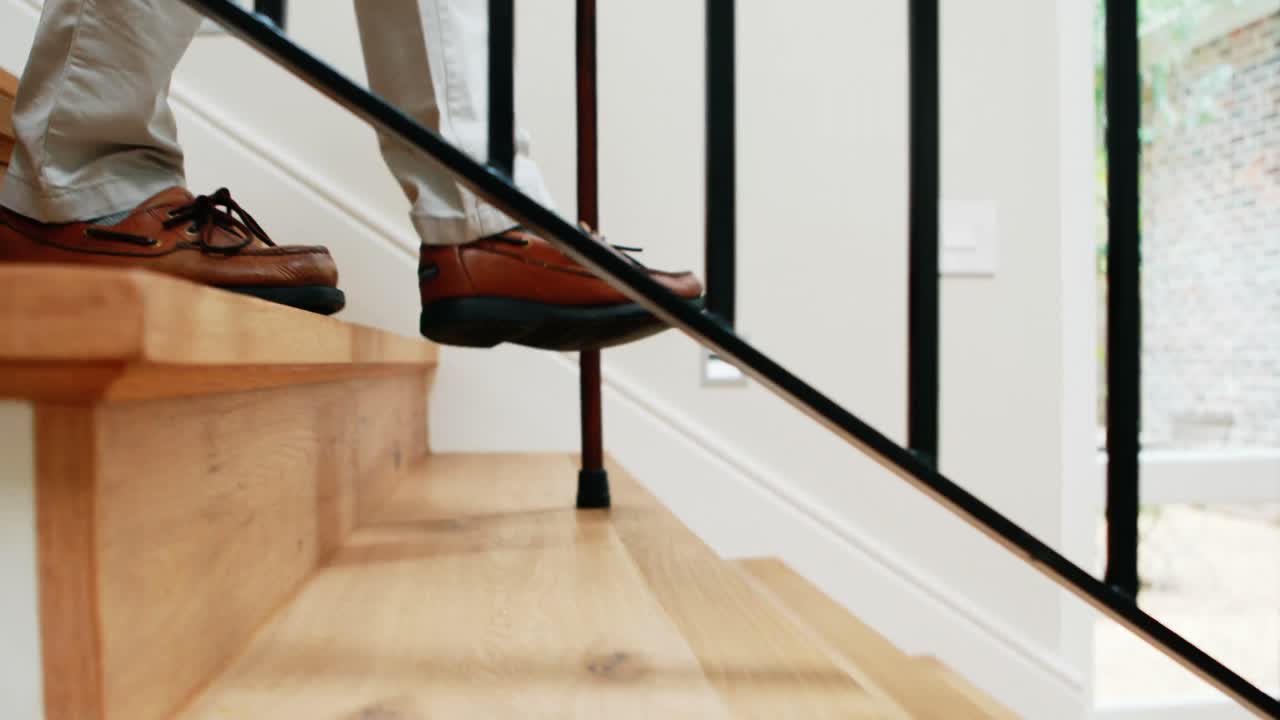 hombre mayor bajando las escaleras con un bastón de caminar