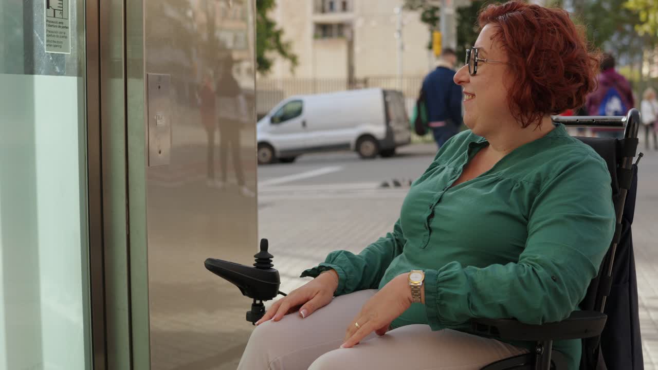 Woman using wheelchair lifts button