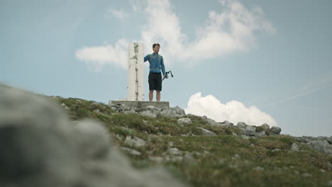 wanderer erreicht ein felsmonument, berührt es und setzt seine reise fort