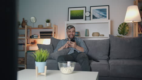Man Relaxing on Couch with Phone