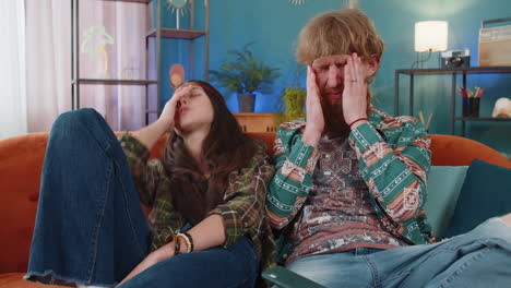 family couple man woman use smartphone surprised by bad news fortune loss fail lottery results