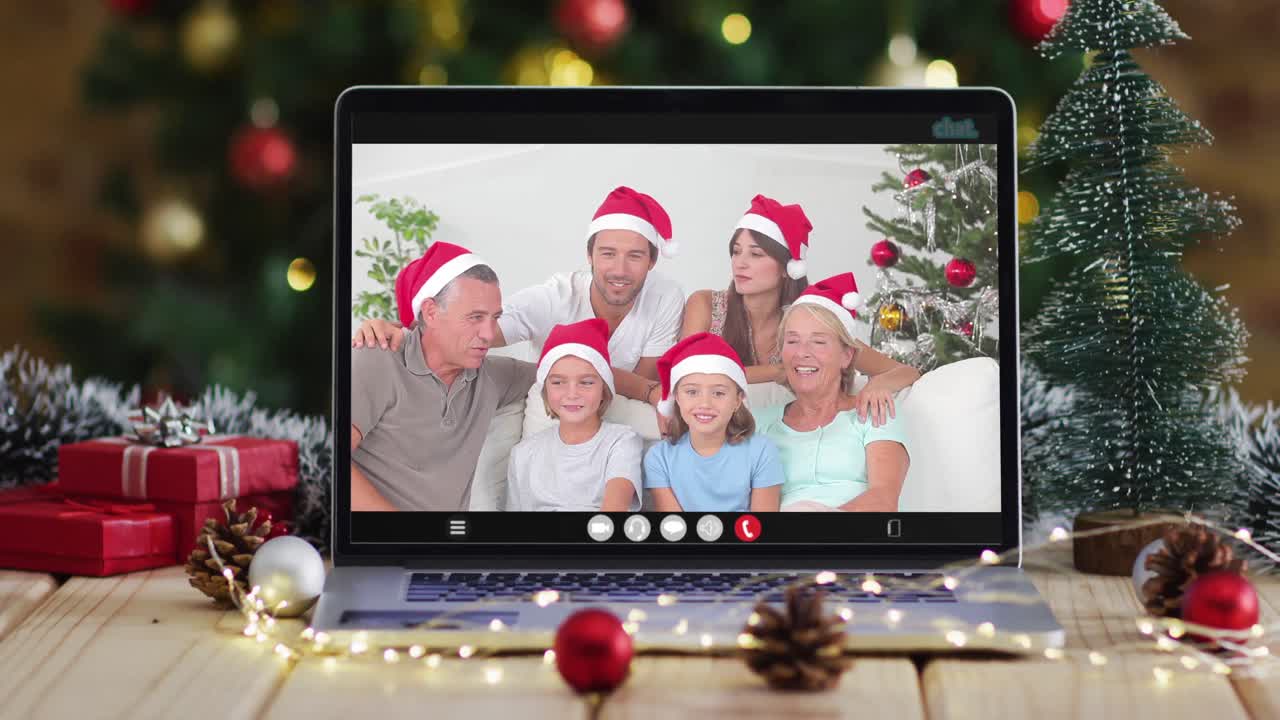 familia feliz usando sombreros snata en videollamada en computadora portátil, con decoraciones de navidad y árbol