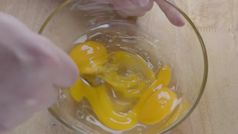 slow motion shot of starting to whisk eggs with a fork in the kitchen