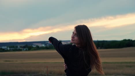 medium shot of beautiful girl pointing at distant place and looking to camera