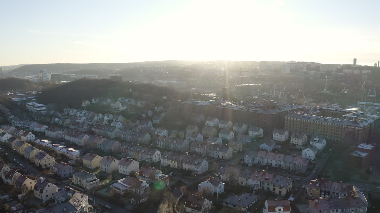 Drone shot over small houses and city landscape in Gothenburg, Sweden during sunrise.