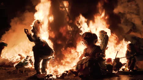 burning figures in a large bonfire at night
