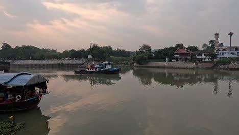 boats gliding on a calm river at sunset