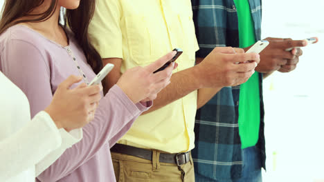 Creative-business-team-using-their-phones-in-a-row