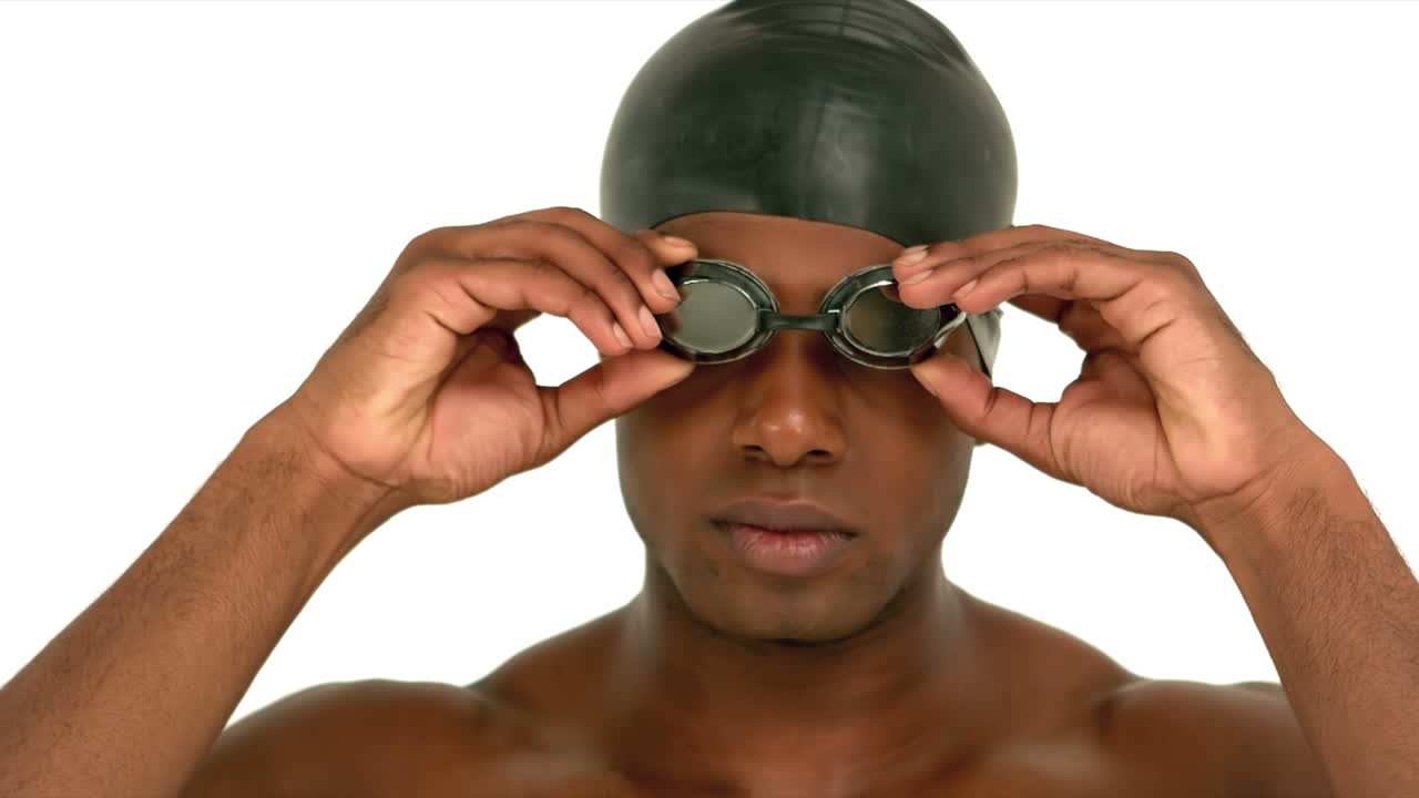 Man putting on swimming goggles