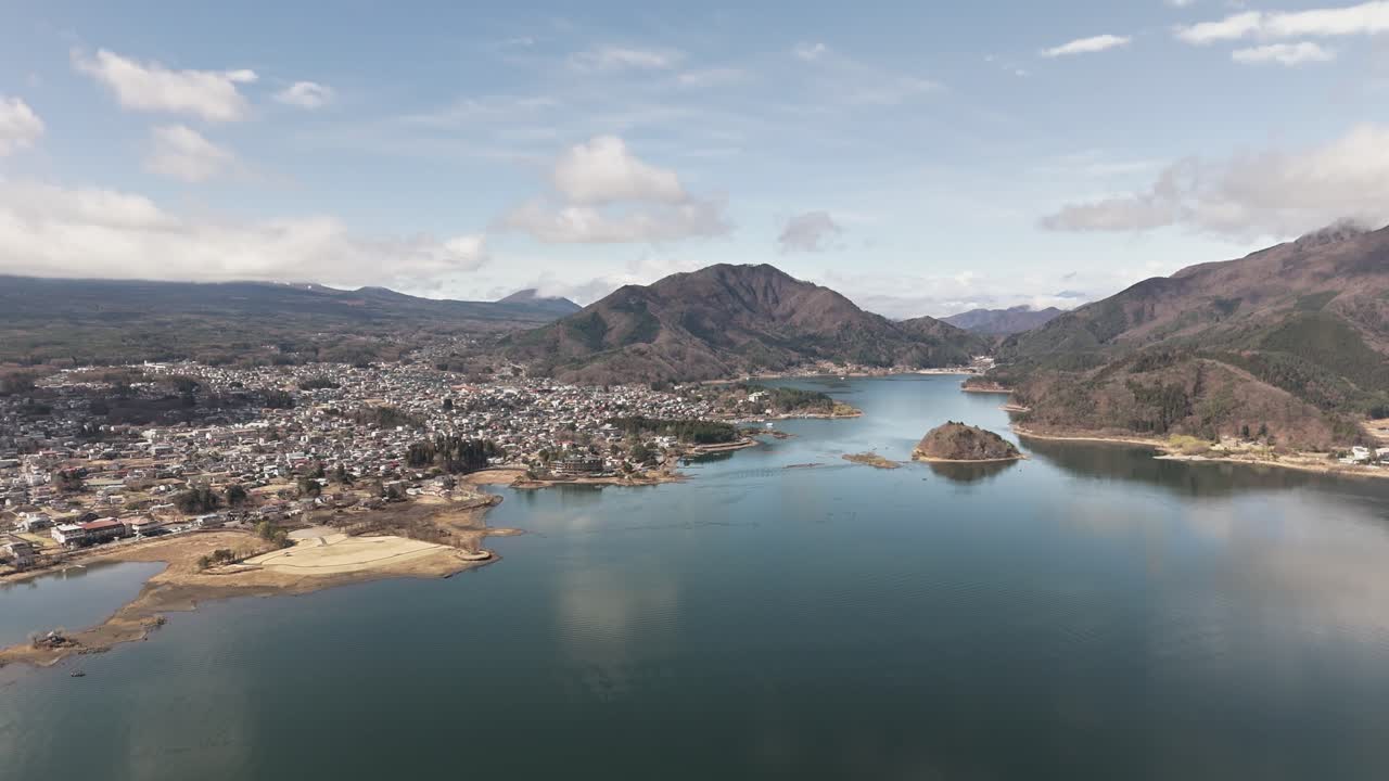 Aerial view of a lake surrounded by mountains and a town