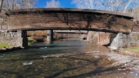 beautiful mountain stream with shallow rapids under a wooden covered bridge