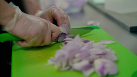 cook very quickly cuts a purple bow on a cutting board