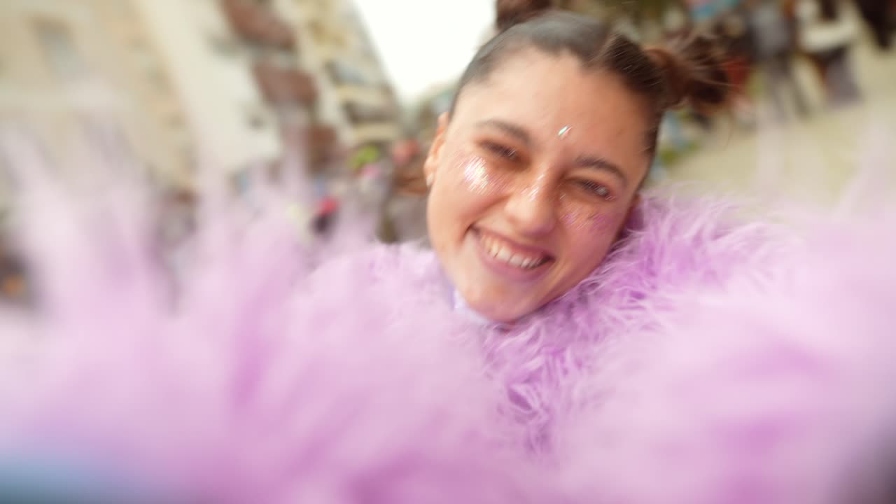 Giovane donna con cappotto soffice viola che registra un video selfie al Carnevale