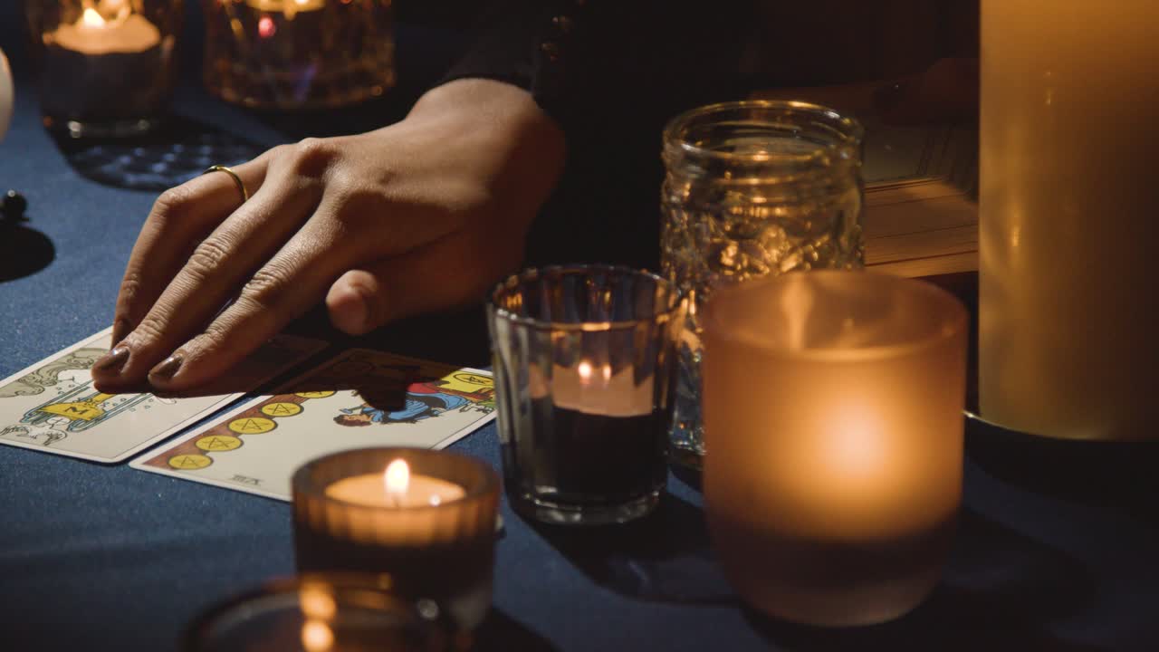 primer plano de una mujer dando una lectura de cartas de tarot en la mesa a la luz de las velas 3