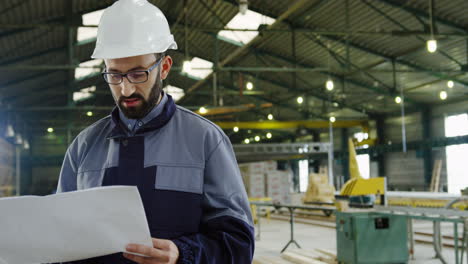 ingeniero caucásico con casco y gafas en una gran fábrica