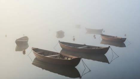 serene morning mist: a tranquil scene of rowboats floating in a foggy lake, capturing the beauty of stillness and reflection in nature's embrace