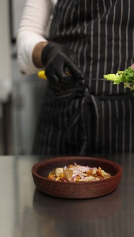 chef preparando un plato con ensalada y setas