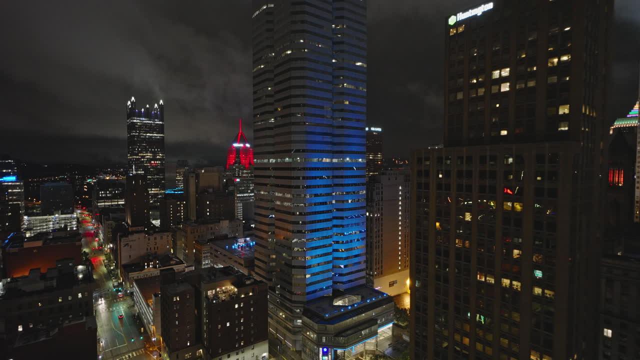 Pittsburgh, Pensilvânia. Sobrevoo aéreo baixo v50 sobre o centro, capturando luzes de rua urbanas e a paisagem urbana iluminada com nuvens densas envolvendo o céu noturno. Filmado com Inspire 3 8k - 24 de setembro de 2023.