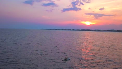 Tranquil-fishing-at-sunset-as-a-kayaker-is-revealed-out-on-the-ocean-by-himself