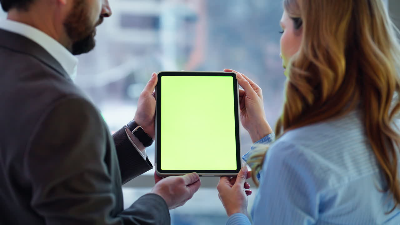 Colleagues watching green screen tablet analysing business data together closeup