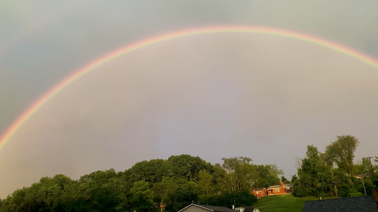 vista panorámica en el arco iris doble en nubes duras lluviosas grises en el día de verano del cielo, 4k