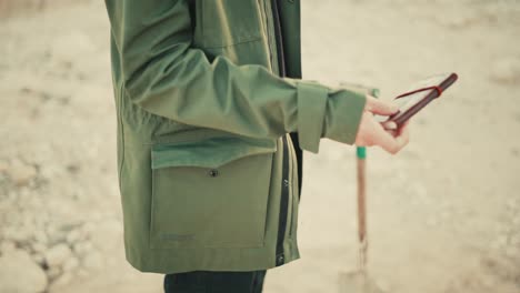 Un-Hombre-Saca-Lentamente-Un-Cuaderno-De-Cuero-Antiguo-De-Su-Bolsillo-Al-Aire-Libre