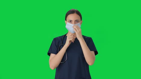 Indian-female-doctor-putting-mask-on-Green-screen